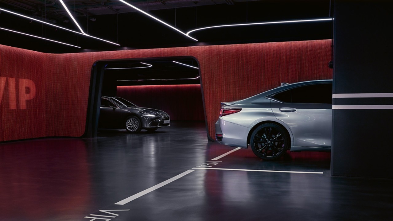 A silver and black Lexus ES parked in a lit up garage 