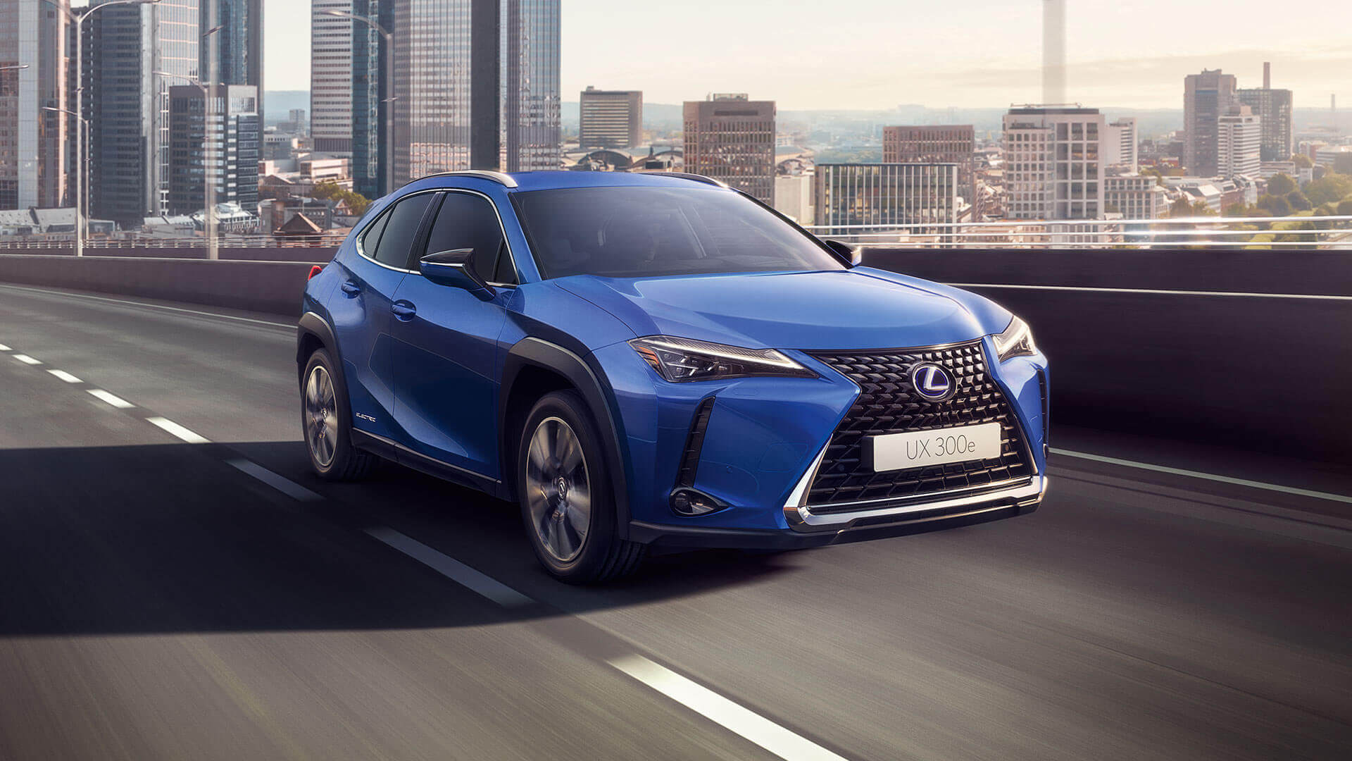 A Lexus UX 300e driving in a city location 