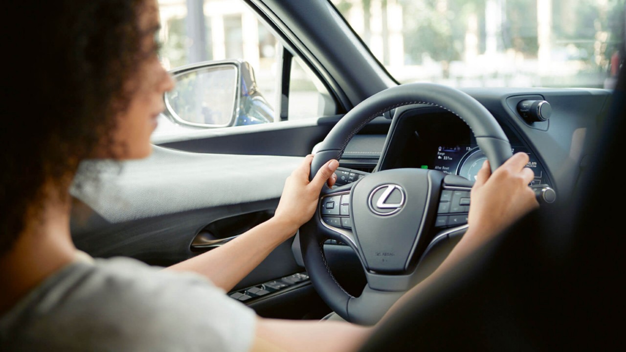 A woman driving a Lexus UX 300e