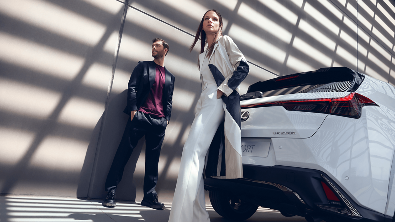   A man and women stood next to a Lexus UX F Sport